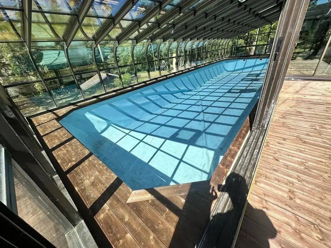 Glasstak over basseng med terrasse i tre