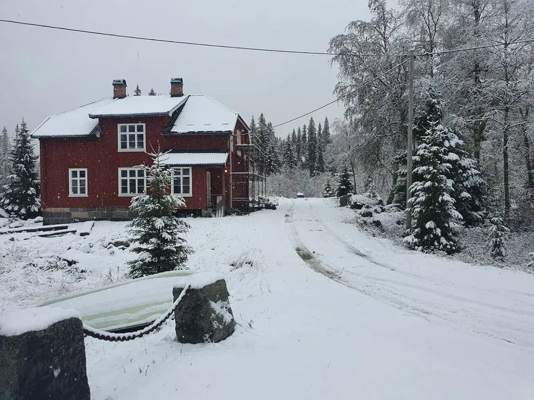 Eldre rødt hus i vinterlandskap