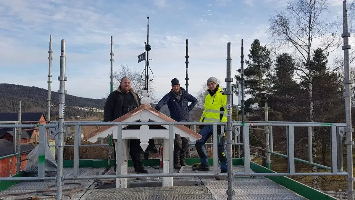 Tre av fagfolkene i Hakadal Bygg AS på stillas under takarbeid